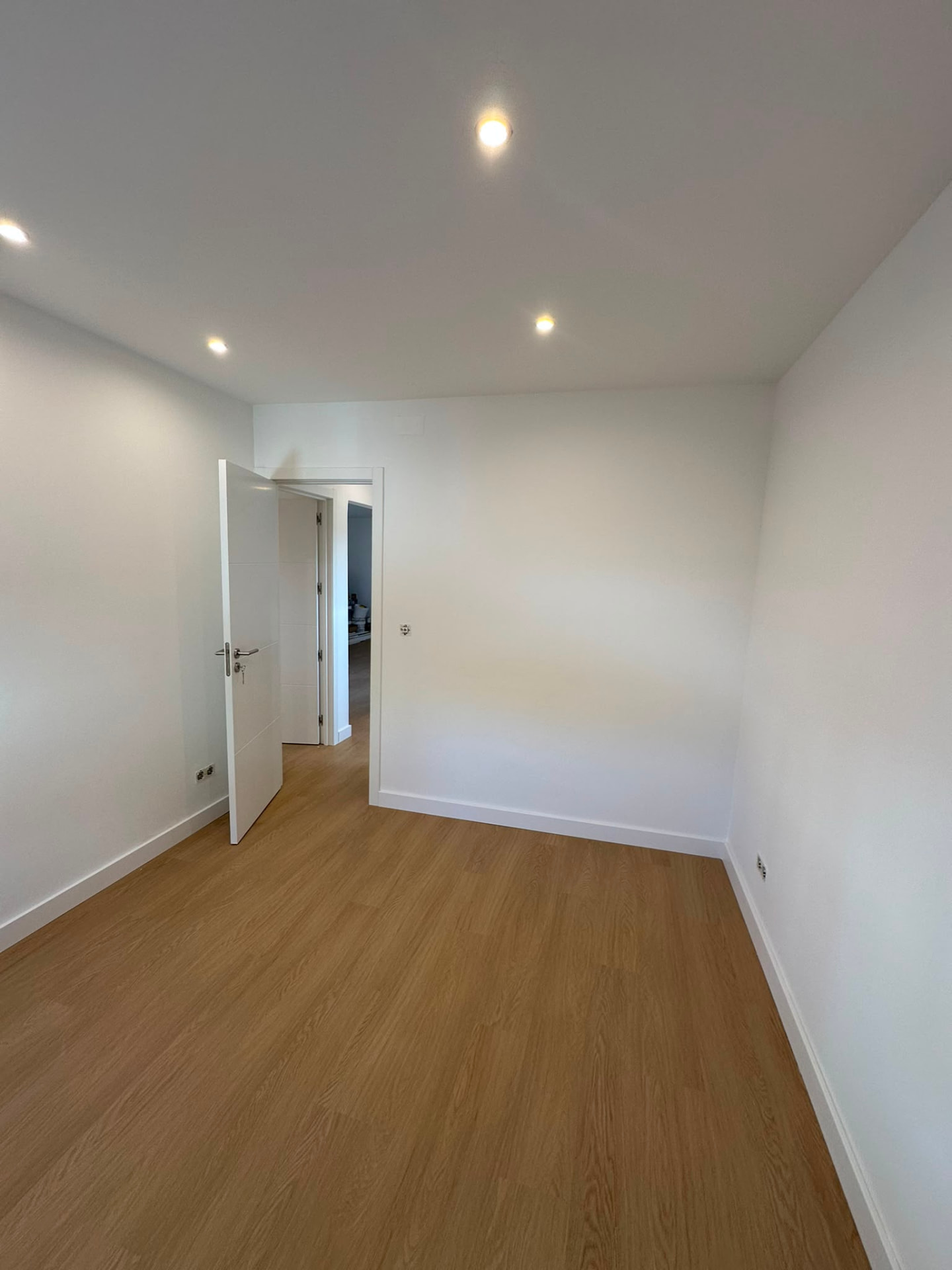 Quarto finalizado com porta lacada a branco e rodapés novos