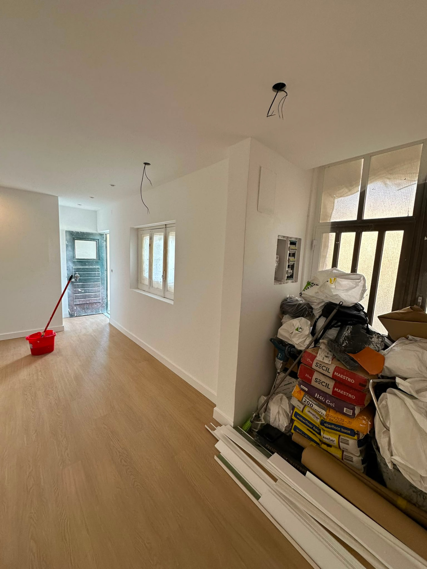 Espaço interior remodelado com pavimento colocado e materiais de obra a finalizar