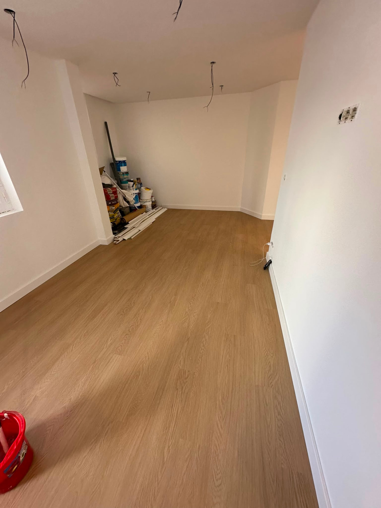 Sala em fase final de obra com pavimento colocado e paredes pintadas