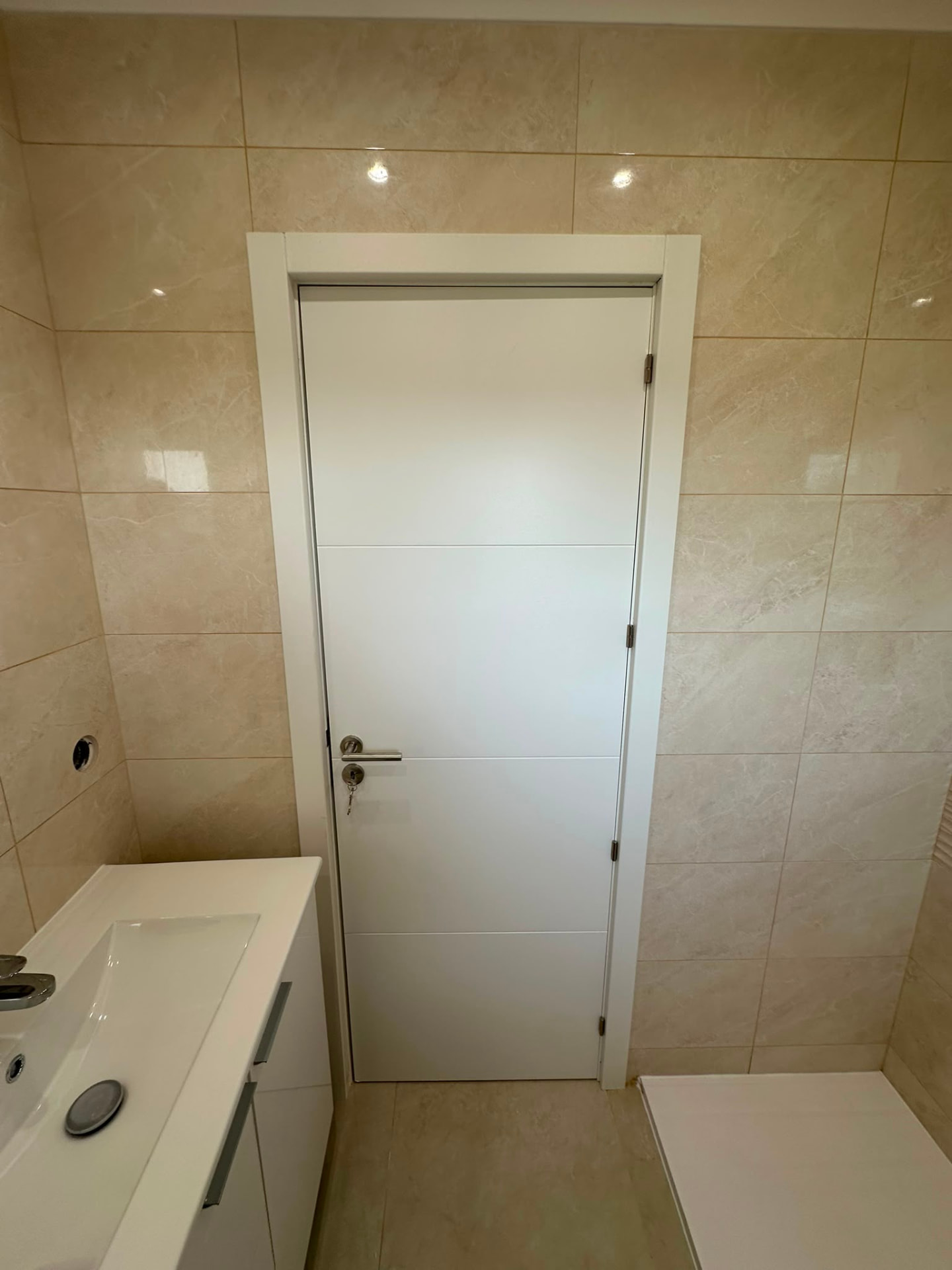 Casa de banho com ladrilho efeito mármore de grande formato e base de duche
